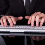 man typing on wireless keyboard
